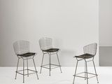 three chairs in a room with a white wall and a white floor