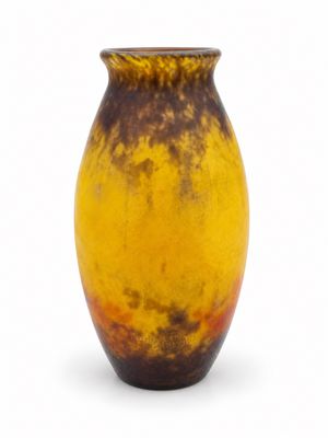 un vase marron et jaune posé sur une surface blanche
