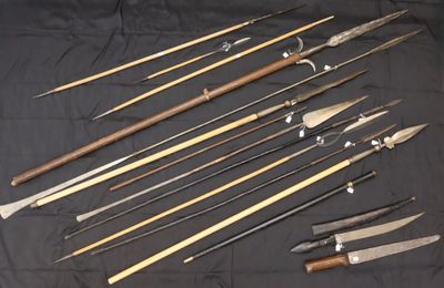 a bunch of different types of knives on a black cloth
