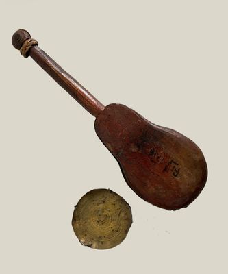 a wooden instrument with a wooden handle next to a metal object