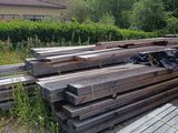 un tas de bois posé sur le sol à côté d'un bâtiment