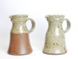 two vases sitting next to each other on a white surface