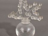 un vase en verre transparent contenant des fleurs, posé sur une table