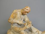 une figurine représentant un homme assis par terre