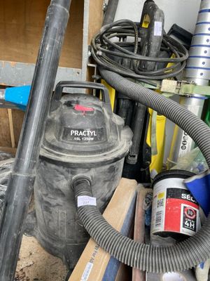 un aspirateur posé à côté d'un tas d'outils