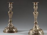 paire de bougeoirs anciens en argent sur un socle, sur fond gris