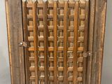 an old wooden cabinet with a lattice design on the door