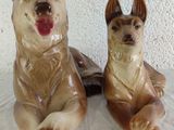 two figurines of dogs sitting next to each other