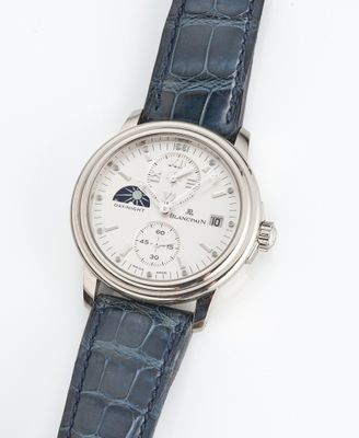 gros plan d'une montre sur une surface blanche avec un bracelet bleu