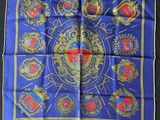 a close up of a blue scarf with gold and red emblems