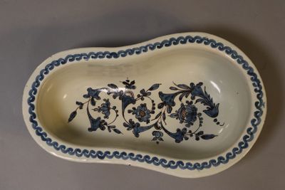 an old blue and white dish with a floral design on it