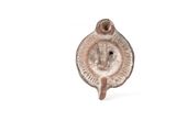 un petit objet métallique sur lequel est représenté un visage