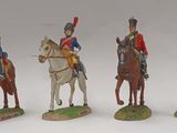 four figurines of soldiers riding horses on a white surface