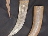 two pieces of metal and a knife on a black cloth