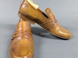 pair of men ' s brown leather shoes on a grey surface