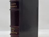 a black book sitting on top of a table next to a white wall