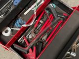 a red tool box with tools in it on the floor