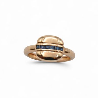 a close up of a gold ring with blue sapphires