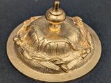 a gold plate with a bird on it on a blue surface