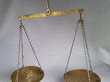 une balance en or dont pendent des chaînes de chaque côté