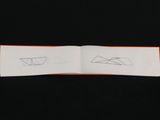an open book with a drawing of a paper boat on top of it