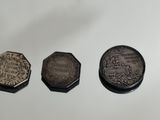 four different types of coins are shown on a white surface