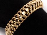 a close up of a gold bracelet on a napkin