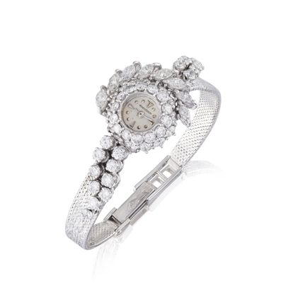 un gros plan d'une montre-bracelet sertie de diamants sur fond blanc