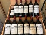 bottles of red wine in a wooden case on display in a store