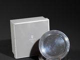 silver plate and box on a black surface with a black background