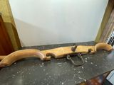 un objet en bois posé sur une table, sur laquelle se trouvent une paire de ciseaux
