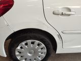 a white car that has been dented and is parked in a garage