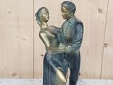 une statue représentant un homme et une femme tenant un bébé dans leurs bras