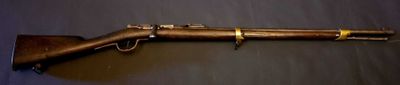 a close up of a rifle mounted on a wall near a wall