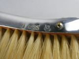 a close up of a brush with a metal handle