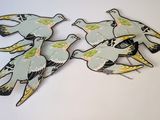 several birds are flying in the air on a white surface