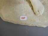 un gros plan sur une sculpture représentant le pied d'une personne posé sur un rocher
