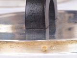 a black ring sitting on top of a silver plate