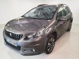 La voiture grise est garée dans une grande pièce au sol blanc.