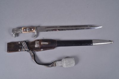 deux couteaux et une corde posés sur une surface blanche