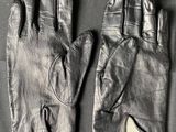 pair of black leather gloves on a table with a white tag