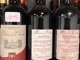 bottles of red wine are lined up on a shelf in a store