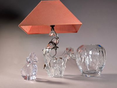 three crystal figurines and a lamp on a table