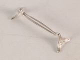 silver plated spoon with a curved handle on a white surface
