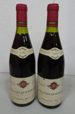 two bottles of red wine sitting next to each other on a table