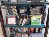 de nombreux DVD et CD empilés sur une étagère dans une pièce
