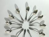 a lot of spoons arranged in a circle on a white surface