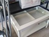 a white coffee table with a glass top and a metal frame