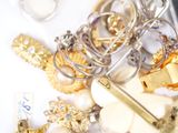a pile of jewelry and a cell phone on a table