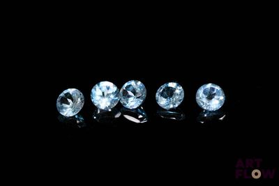 un ensemble de cinq diamants de couleur topaze bleue posés sur une surface noire